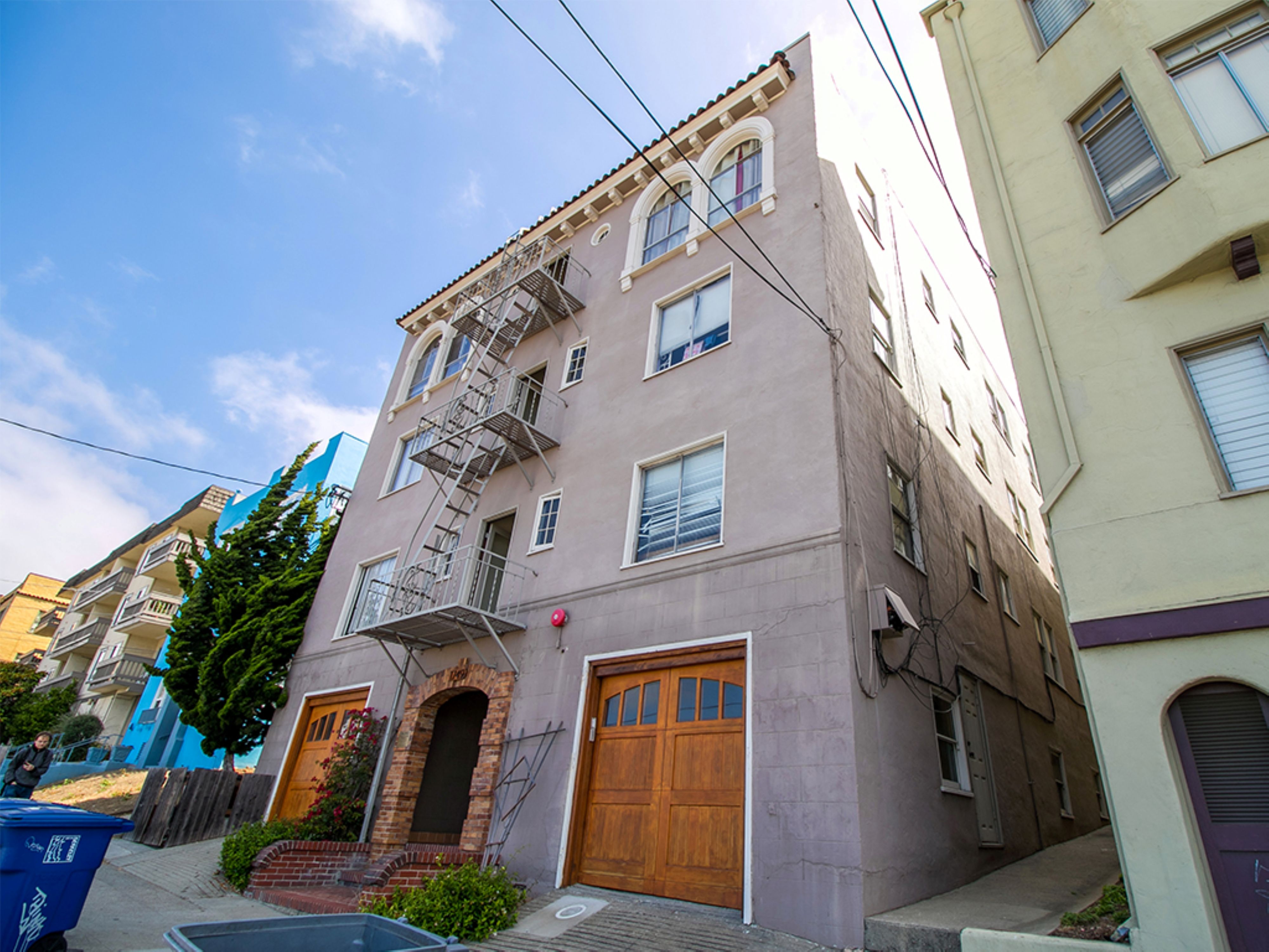 A building with a brown door and a fire escape.